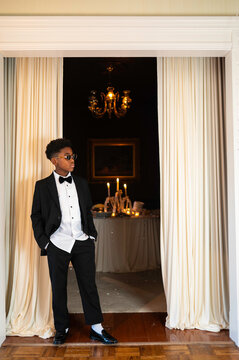 Boy in Suit Stands at Doorway During Event