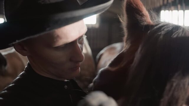 Gentle connection between man and foal. Tender interaction during training inside cozy barn stall. Emotional and gentle bonding experience between caretaker and foal in rustic stable setting