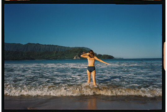 walking into the ocean shoreline of beach traveler getting feet wet