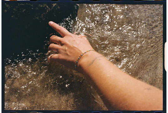 hand reaching toward rock water
