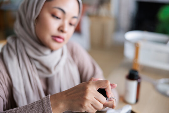 Woman in hijab prepares essential oils.