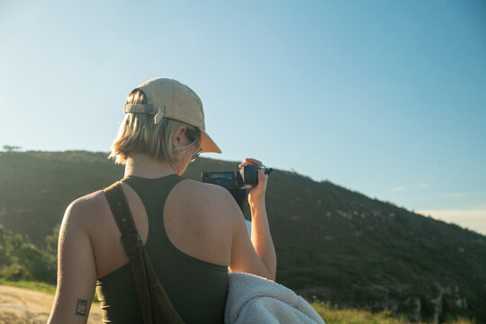 Blonde woman filming dark woman in nature