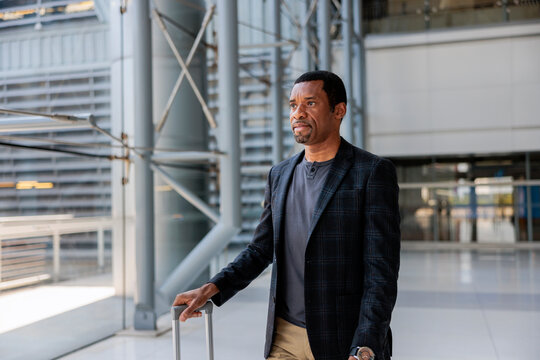 Man with suitcase in modern airport terminal.