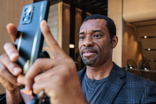 Man takes photo with phone indoors.