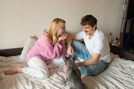 A young couple with a dog spend time in an apartment