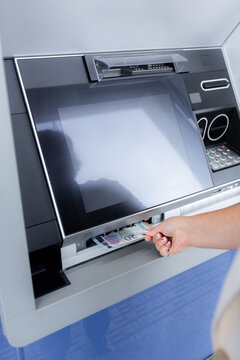 Person Withdrawing Cash From an ATM in a Public Area