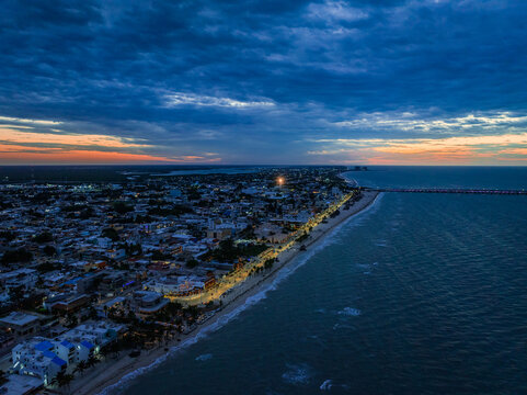 Aerial view of the Peninsula de Yucatan coastline at dusk with the city lights of Progreso and a long pier stretching into the Gulf of Mexico Yucatan, Mexico.