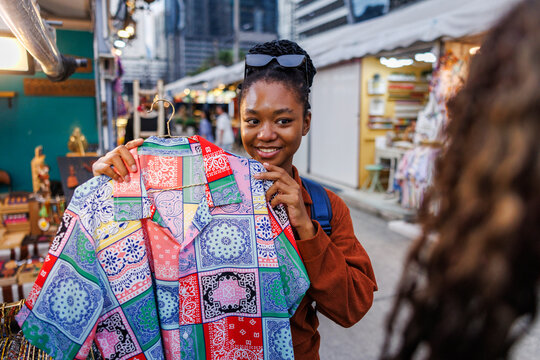 Tourist holding up shirt for friend's opinion