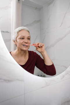 A woman brushes her teeth
