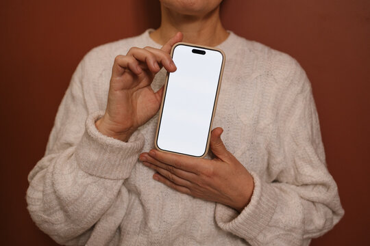 A woman shows a mobile phone with white screen