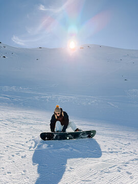 Snowboarder adjusting bindings