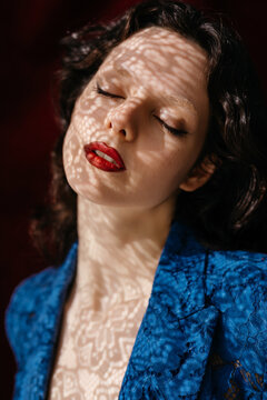 Woman with closed eyes and lace shadows