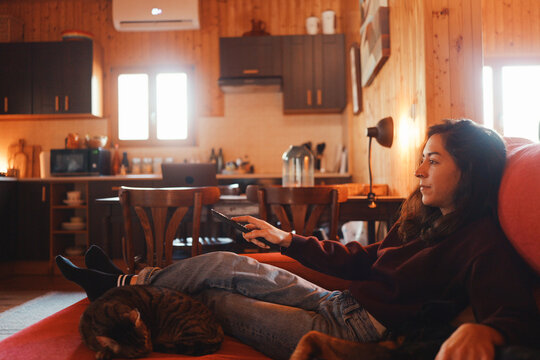 Woman using remote control of the tv