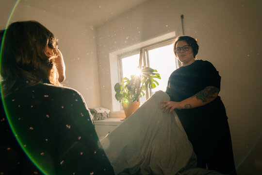 People in a Room Preparing Bedding During Daylight