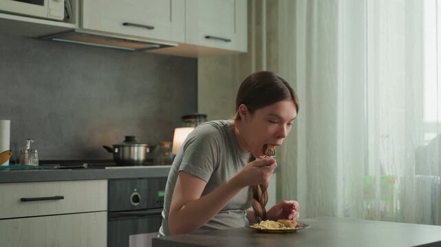 Pregnant white woman eating with delight at kitchen table, chewing slowly with satisfied exhale, plate of homemade food, relaxed posture, maternal nourishment and contentment in cozy light