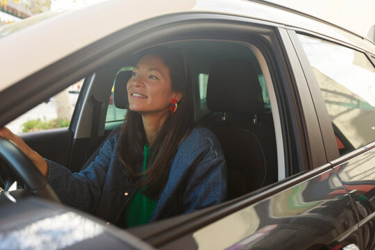 Woman Driving a Car in a City Setting During Daytime Hours