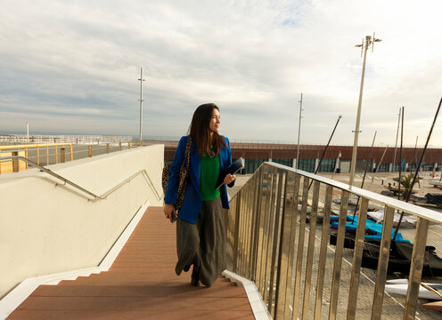 Woman Walks on Dock Near Boats in Cloudy Weather