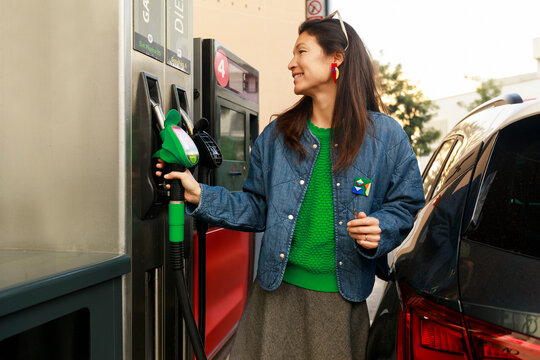 Woman Fills Gas at a Station in the Afternoon Light