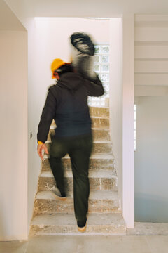 Worker carrying construction material, walking upstairs