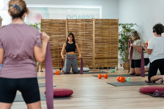 Women doing pilates with elastic bands in group class