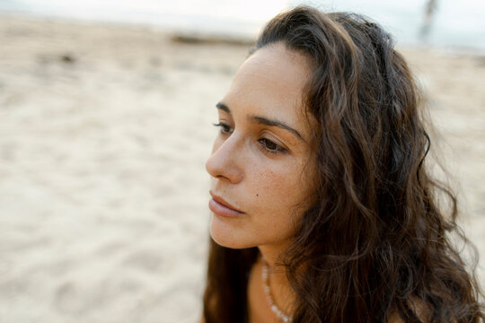 Peaceful portrait of a woman gazing into the distance at the beach