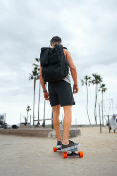 Man skateboards at beach path
