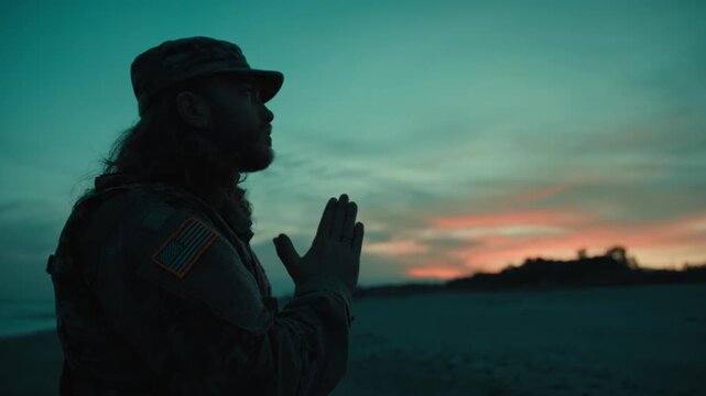 Silhouette of American soldier praying at sunset during Memorial Day Celebration