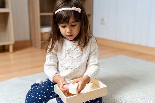 Child Examining Wooden Toy