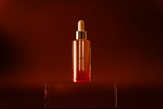 Comsmetic bottle with dropper on glass platform. 