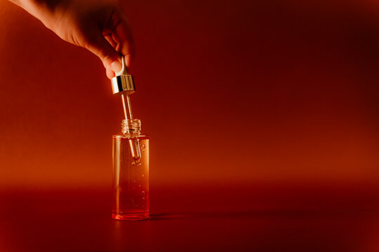 Hand holding a dropper in cosmetic bottle