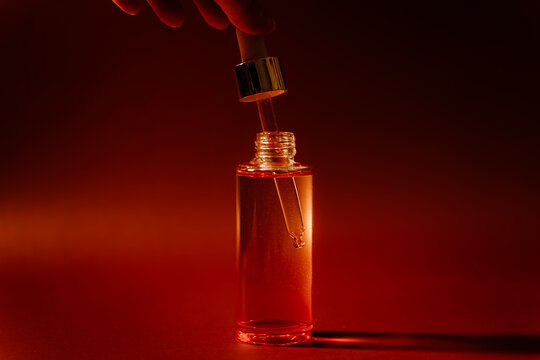Hand holding a dropper in cosmetic bottle