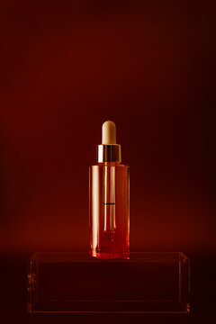 Comsmetic bottle with dropper on glass platform. 