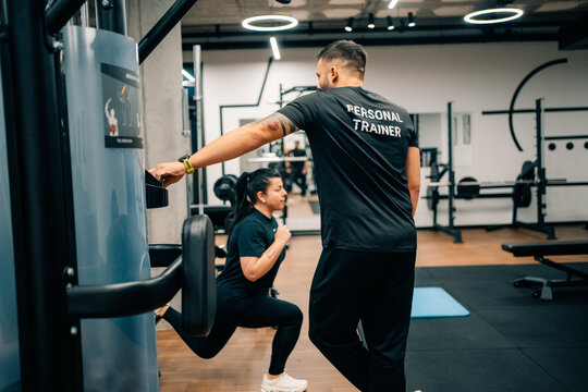 Trainer Guides Client During Workout Session at Gym in the Morning