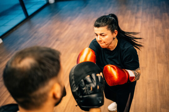 Training Session in Boxing Ring With Woman and Coach