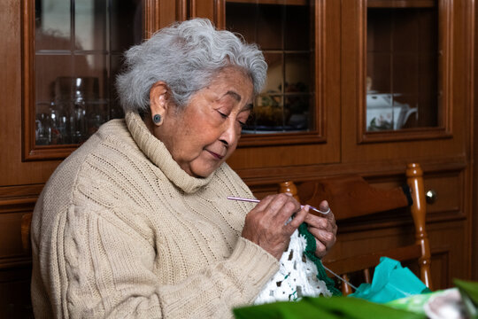 Elderly Woman Crochets in Cozy Home 