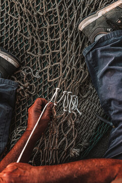 Fisherman mending nets by hand