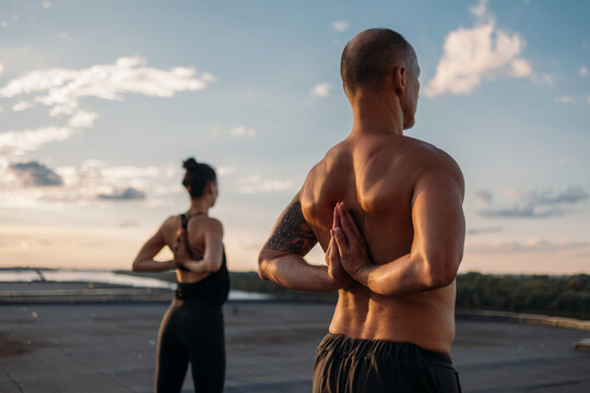 Couple Doing Yoga at Sunset on Rooftop Deck