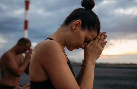 Calm Moment: Woman Prays at Sunset Beach