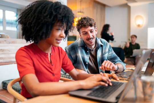 Diverse team collaborating on laptop in modern office