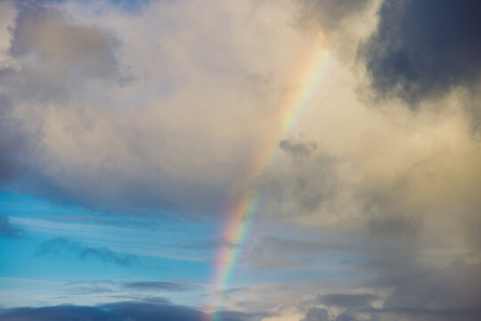 Rainbow appearing through dramatic cloudy sky
