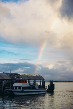 Rainbow Appears Over the Water Near a Boat at the Dock
