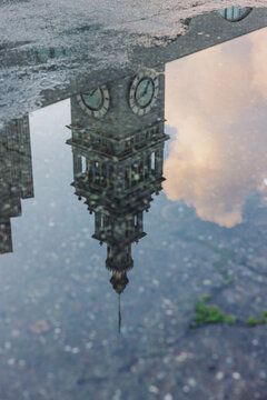 Clock Tower Reflection in Rain Puddle on City Street