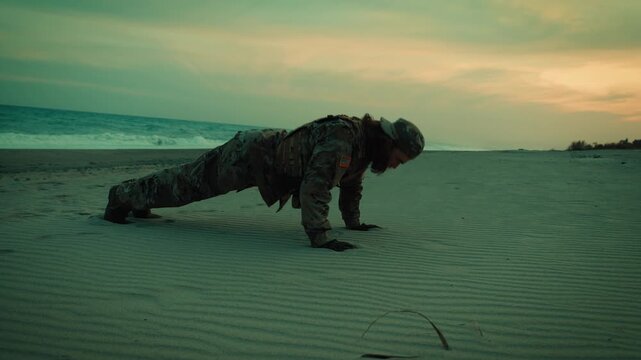 American Navy soldier does push-ups on the beach at sunset for sports training