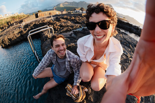 Couple smiling taking selfie at natural pools enjoying summer