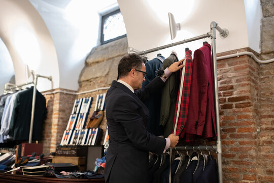 Senior male tailor measuring sleeve of jacket