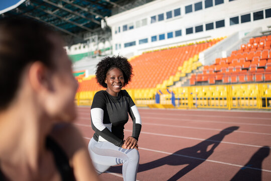 Black sportswoman lunging near friend
