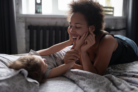 Child girl playing with happy black mother in morning
