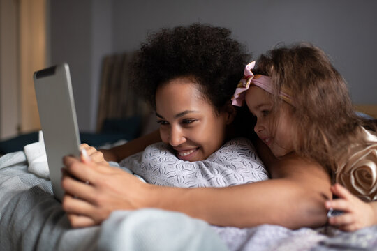 Black mother and daughter having virtual meeting with relatives