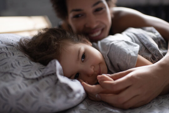 Mother waking up daughter tenderly