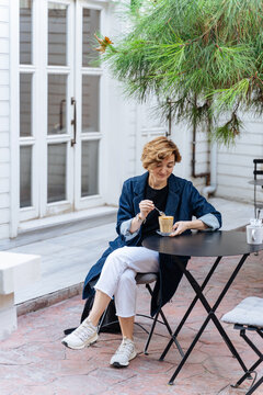 Woman Drinking Coffee at Outdoor Cafe